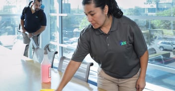 Two janitors cleaning a conference room