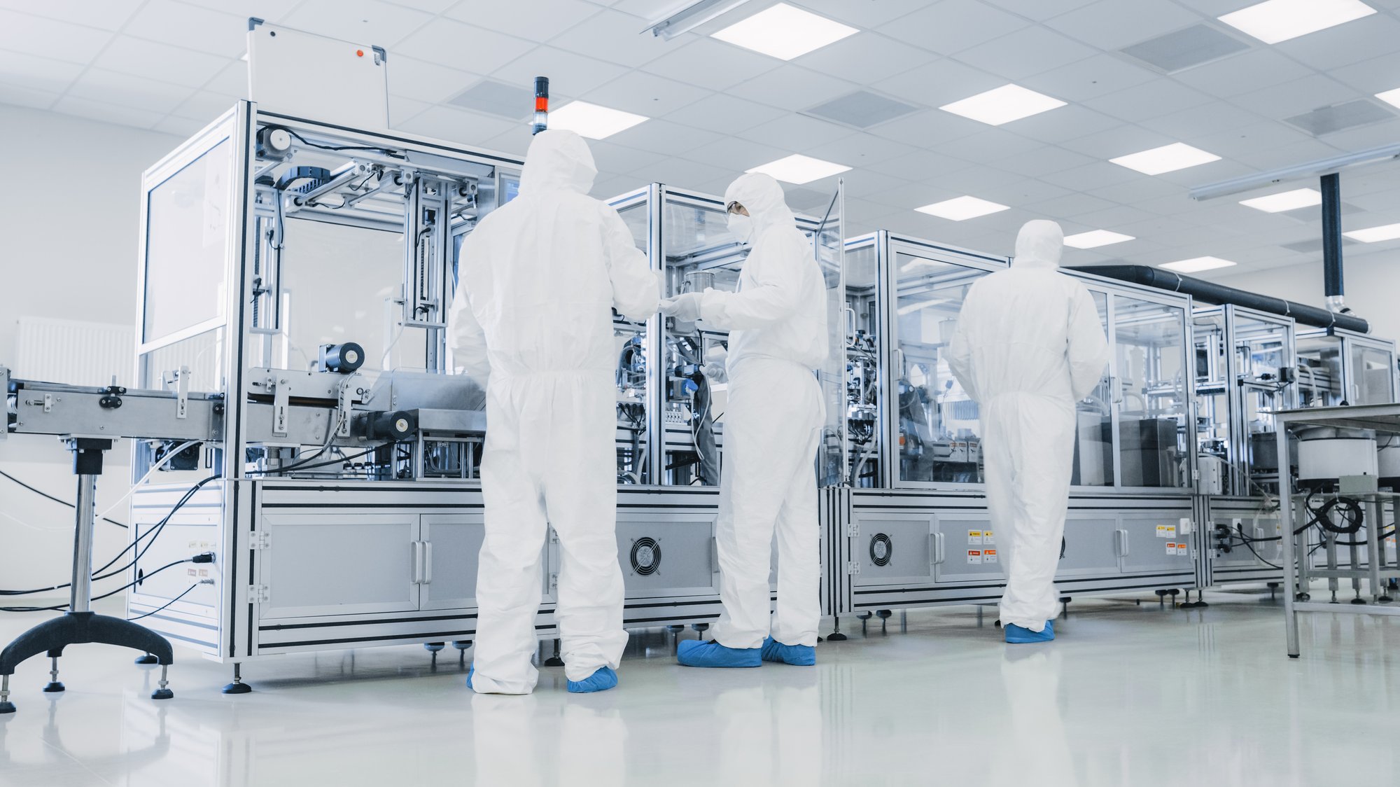 Sterile-suited technicians working in a medical device manufacturing facility